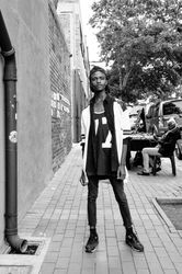 Young man in fashionable clothes posing on sidewalk facing the camera