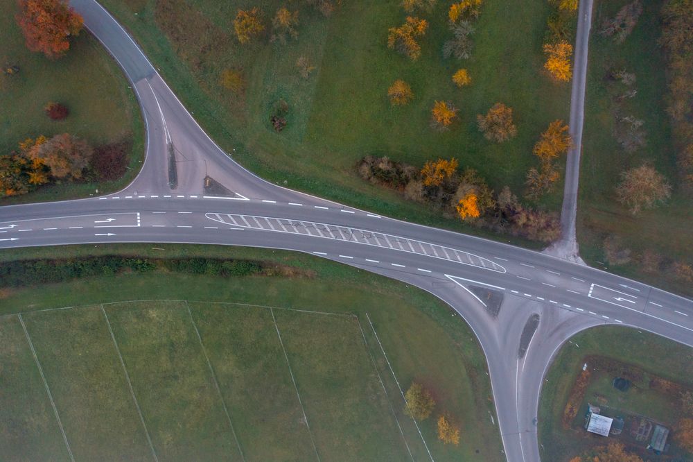 Drone aerial view with road intersection in an autumn scenery, directly above