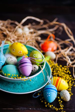 Easter holiday card with bowl of decorative eggs and straw
