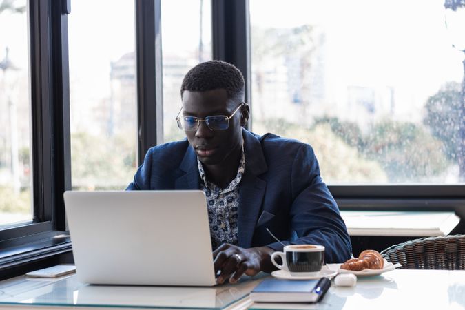 Black man working on laptop in cafe