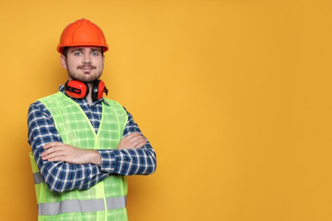Engineer in helmet on yellow background, space for text