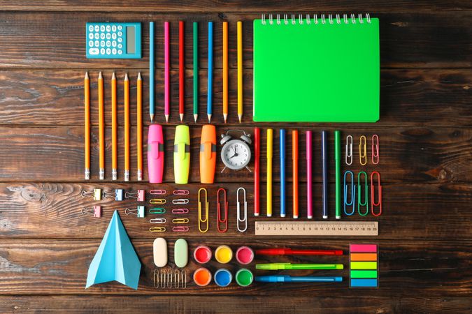 Flat lay composition with school supplies on wooden background, space for text