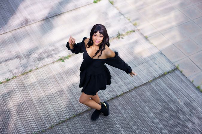 Woman in dark dress dancing outside