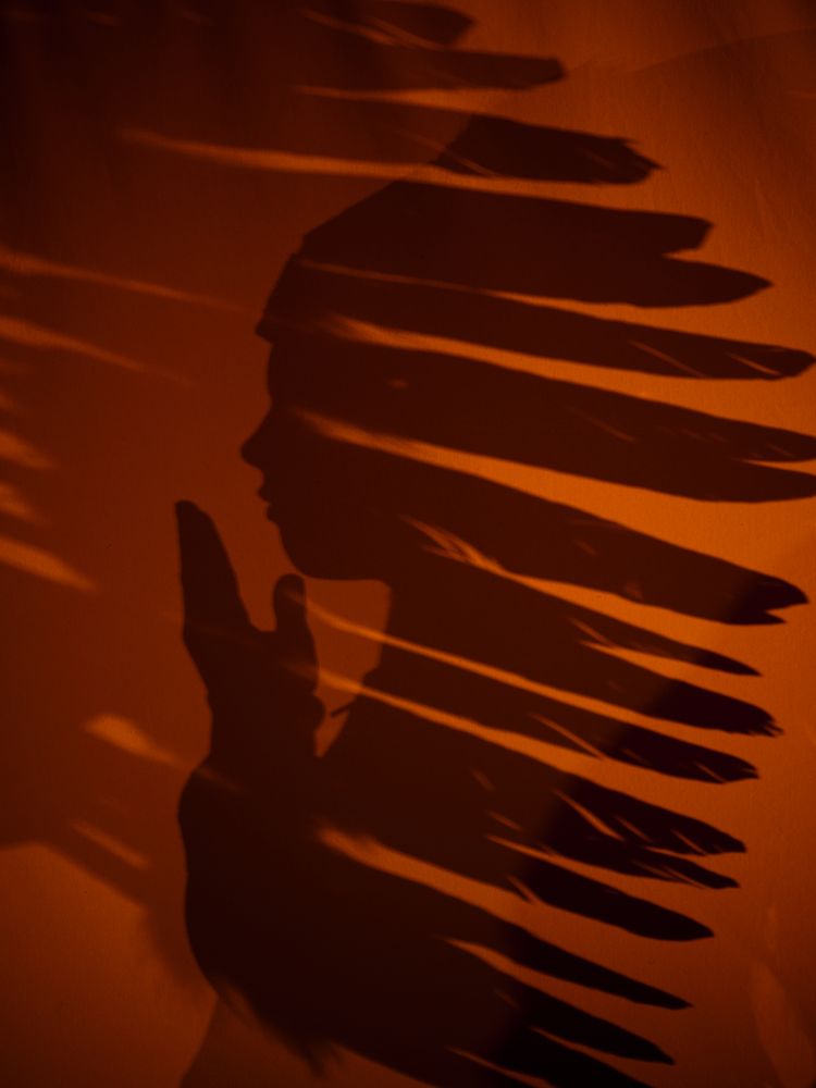 Shadow of anonymous boy in native American headwear