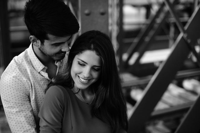 Amorous couple bonding on railway under bridge