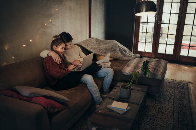 Couple relaxing with a laptop in cozy living room