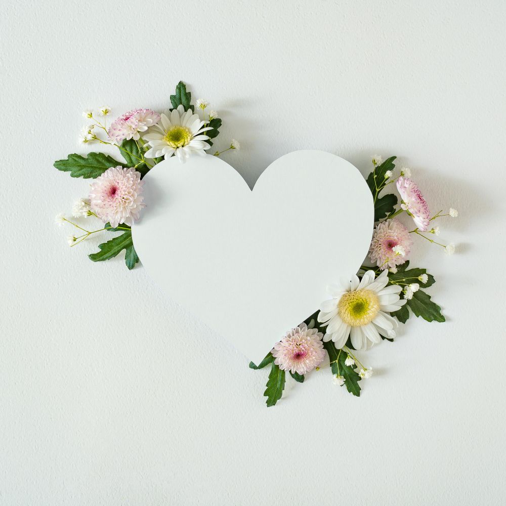 Heart shape paper card note with natural spring wild flowers
