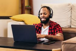 Black man teleworking with laptop from home