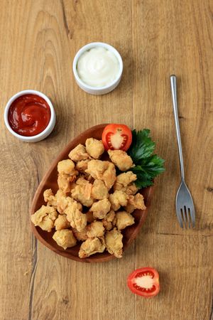 Crispy popcorn chicken served with ketchup and mayo