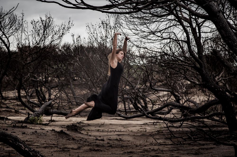 Woman dancing between dry trees