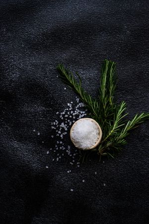 Top view of salt and rosemary on kitchen counter