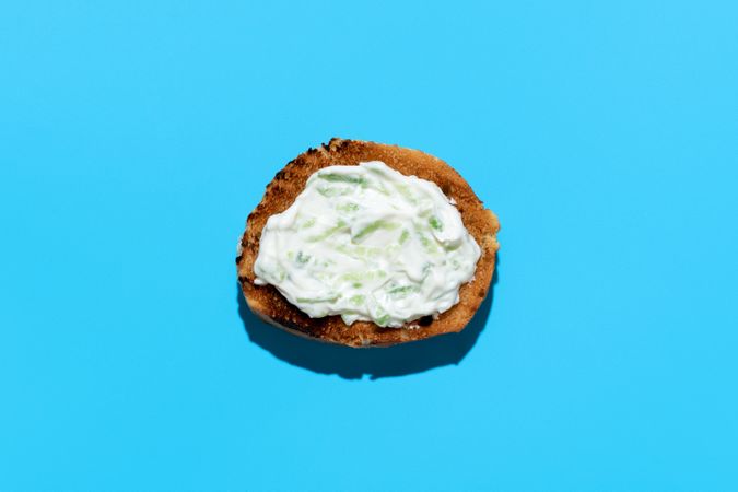 Tzatziki sauce on toasted bread, above view on a blue background