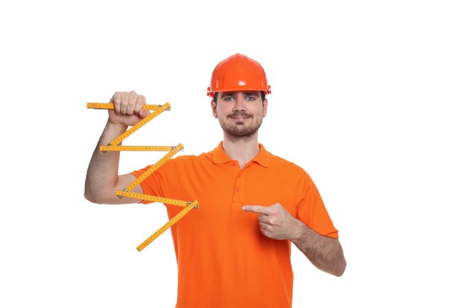 Engineer in helmet with ruler, isolated on light background