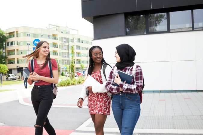 Three female friends talking while walking around campus