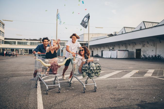 Two young couples pushing each other in shopping carts