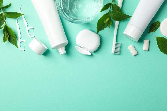 Tools for dental care on mint background, top view
