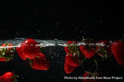 Side view of sparkling water on dark background with strawberries bDRjk5