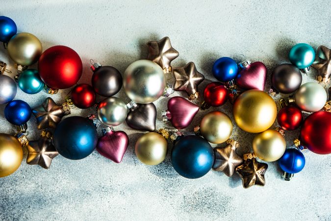 Christmas card concept of colorful baubles in center of concrete counter