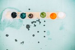 Top view of row of ink pots on blue paper