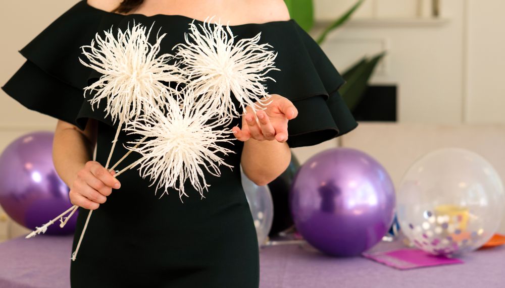 Woman in dress holding white flowers at party