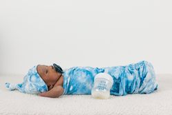 Newborn baby wrapped on soft blanket with pacifier