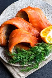 Raw herring fish on plate served with dill and lemon