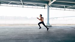 Athletic man sprinting during a bridge