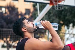 Young man drinking water after doing sports