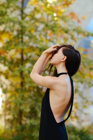 Side view of fashionable woman with hands covering her eyes in nature