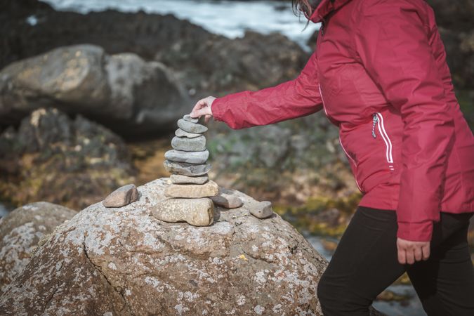 Tourist balancing stones during travel in rocks