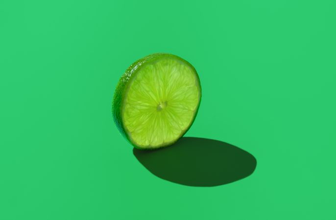 Lime slice isolated on a green background