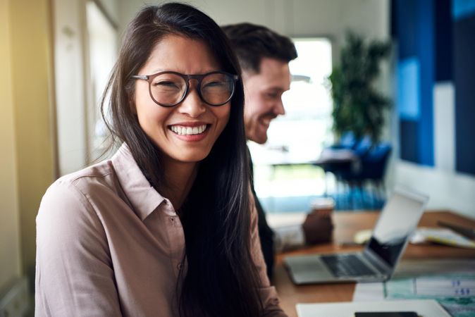 Portrait of happy business woman in a meeting with colleagues