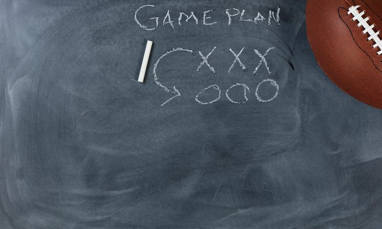 American football with game plan on chalkboard