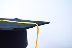 Graduation cap in plain studio with copy space