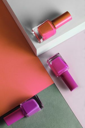 Multi-colored nail polish on pastel colors geometric pattern background