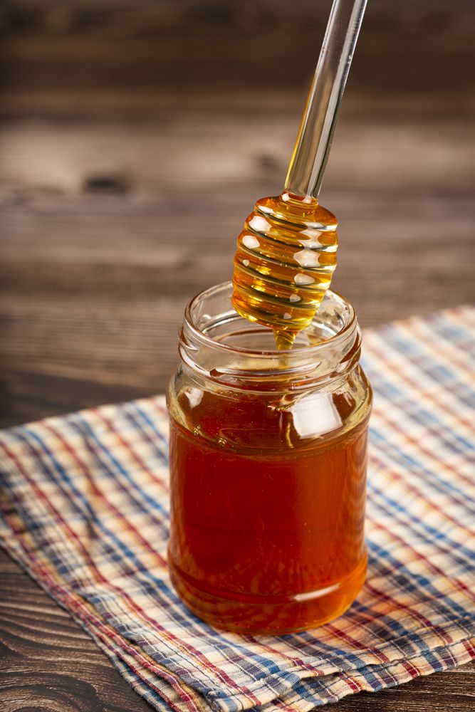 Honey in glass jar on the table.