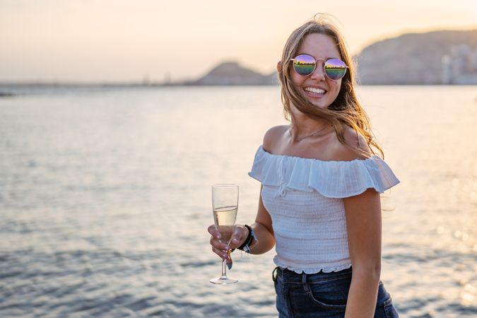 Young woman enjoying wine near sea