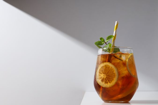 A glass of delicious cold tea on a plain background