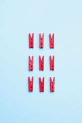 Red clothes pins on light blue background