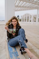 Content woman eating salad from plastic bowl sitting on wooden terrace