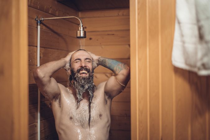 Man taking shower in wooden bathroom