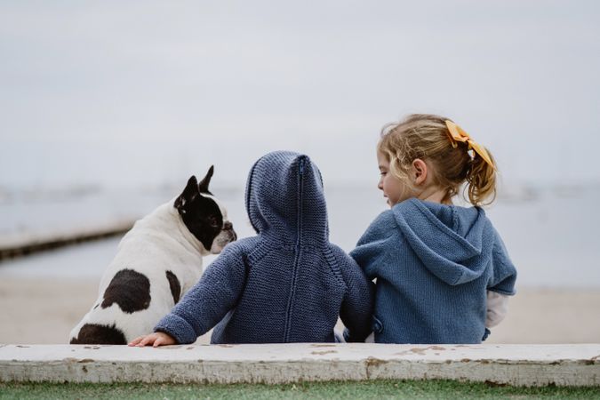 Kids hugging dog on beach