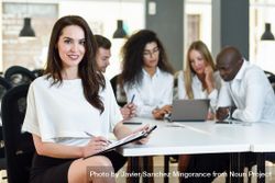 Brunette businesswoman smiling in office looking at camera 0LypD5
