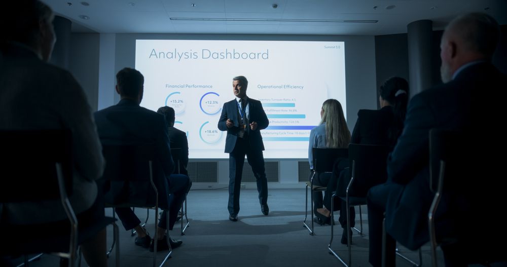 Male Top Manager Walking Between The Rows Of Diverse Audience To Give Presentation At Business Conference.