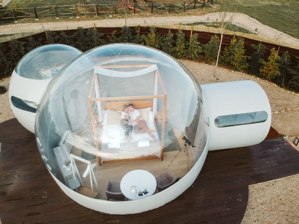 Passionate couple on bed in bubble hotel