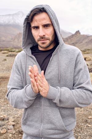 Man in warm sportswear showing Namaste gesture
