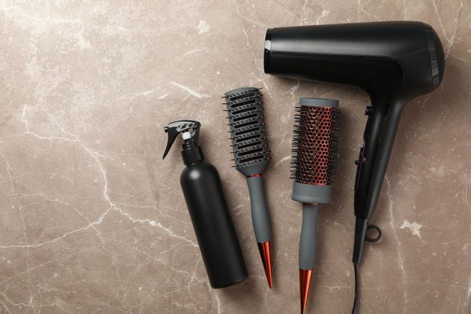 Composition with hairdresser accessories on gray background, top view