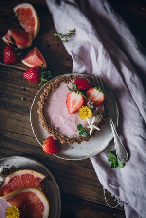Strawberry and citrus cake served on wooden table