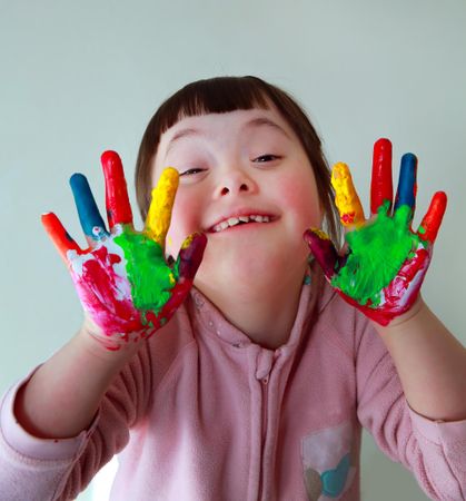Silly little girl holding her painted hands up