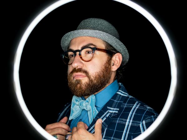 Stylish man in elegant suit behind special circle light